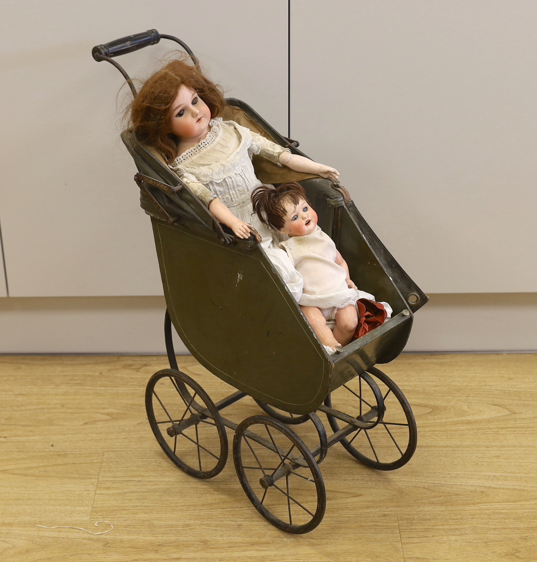 An Armand Marseille open mouth doll, a Heubach Koppelsdorf open mouth doll and an upright dolls pram, pram 66cm high
